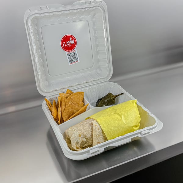 El Flamin Taco burrito in a takeout container with tortilla chips and a roasted pepper.