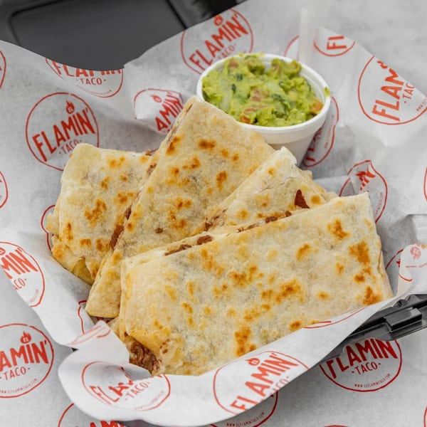 El Flamin Taco quesadillas and guacamole in a basket lined with branded paper.